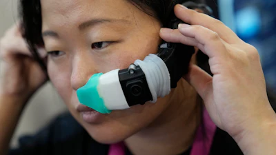 An exhibitor displays the OVR Technology ION 3 stand-alone wearable at the OVR Technology booth during the CES tech show Thursday, Jan. 5, 2023, in Las Vegas. The ION 3 is a wearable device that delivers scents using cartridges, and the delivery system is synchronized with the content users are viewing in VR, AR, and mobile or desktop computing devices.