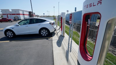 A Tesla charges at a station in Topeka, Kan., Monday, April 5, 2021. Tesla says it sold a record 1.3 million electric vehicles in 2022.