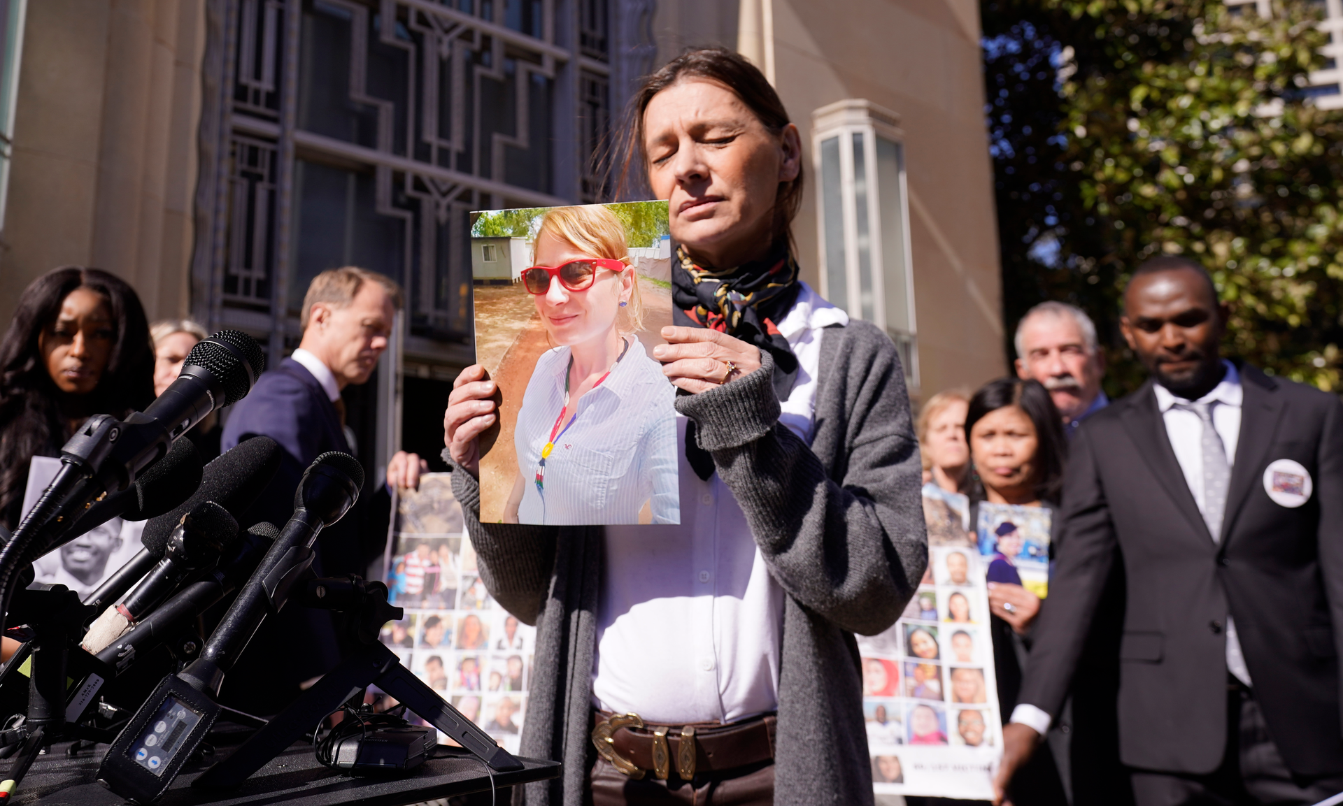 Catherine Berthet, of France, closes her eyes as he holds a photo of her deceased daughter Camille Geoffroy, in front of other families that lost loved ones to crashes of the Boeing 737 Max airliner outside the federal court in Fort Worth, Texas, Thursday, Jan. 26, 2023.