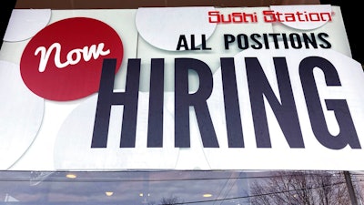 A hiring sign is displayed at a restaurant in Rolling Meadows, Ill., Tuesday, Dec. 27, 2022. On Wednesday, the Labor Department reports on job openings and labor turnover for November.