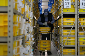 A worker collects parts at SMC, a Japanese pneumatic engineering company factory in Beijing on Jan. 10, 2023. China's trade surplus swelled to a record $877.6 billion in 2022 as exports rose 7% despite weakening U.S. and European demand and anti-virus controls that temporarily shut down Shanghai and other industrial centers.
