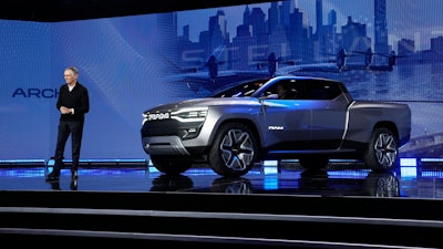 Stellantis CEO Carlos Tavares stands beside the Ram 1500 Revolution electric battery powered pickup truck during the CES tech show Thursday, Jan. 5, 2023, in Las Vegas.