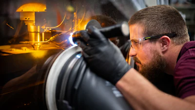 Sandia National Laboratories technologist Levi Van Bastian works to print material on the Laser Engineered Net Shaping machine, which allows scientists to 3D print new superalloys.