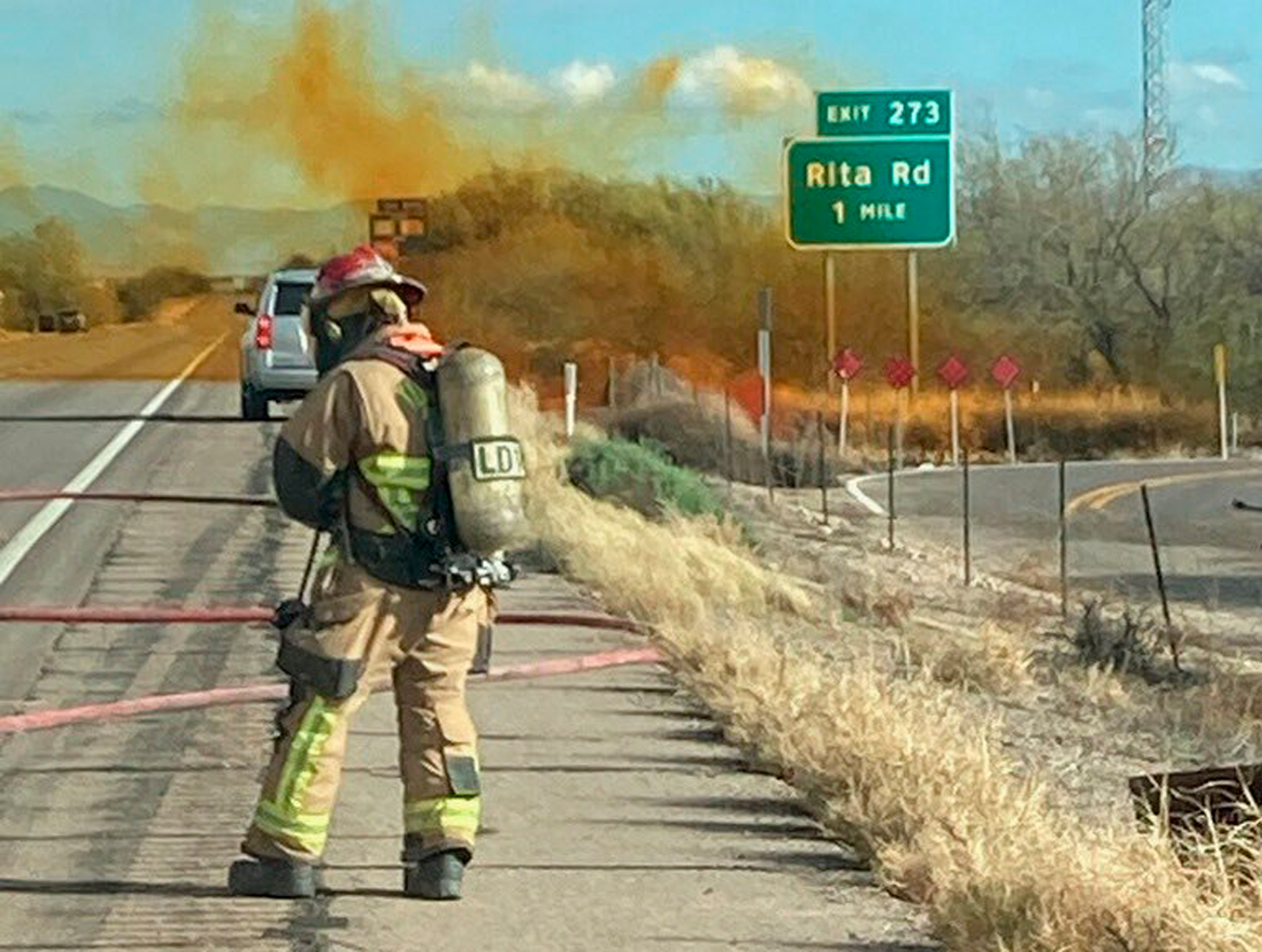 In this photo provided by the Tucson Fire Department, personnel work to control the hazardous material leak and brush fire incidents at Rita Rd. and Interstate 10 near Tucson, Ariz., Tuesday, Feb. 14, 2023.