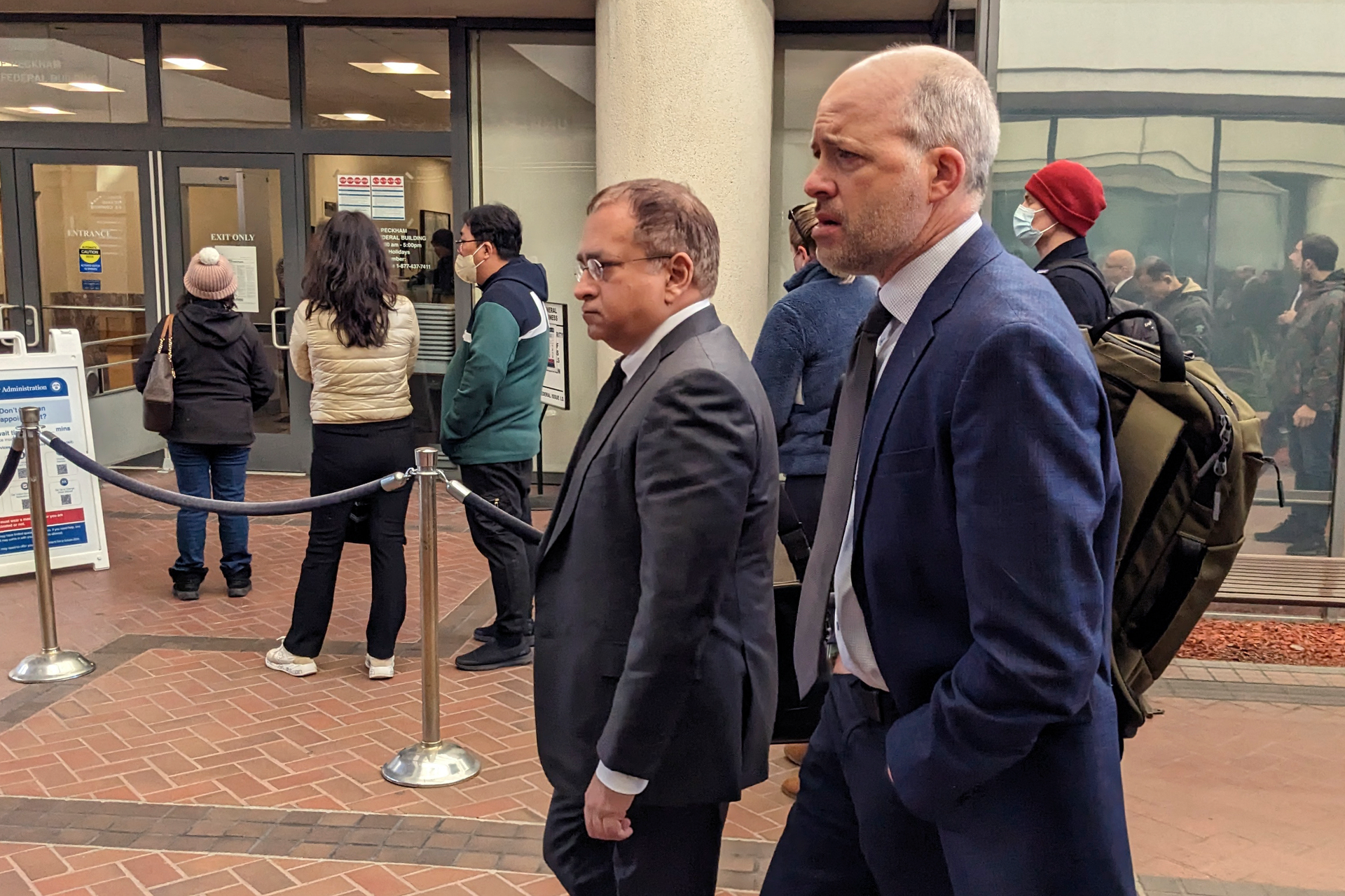 Former Theranos executive Ramesh 'Sunny' Balwani, center, walkes to federal court with his attorney Mark Davies, Friday, Feb. 17, 2023 in San Jose, Calif.