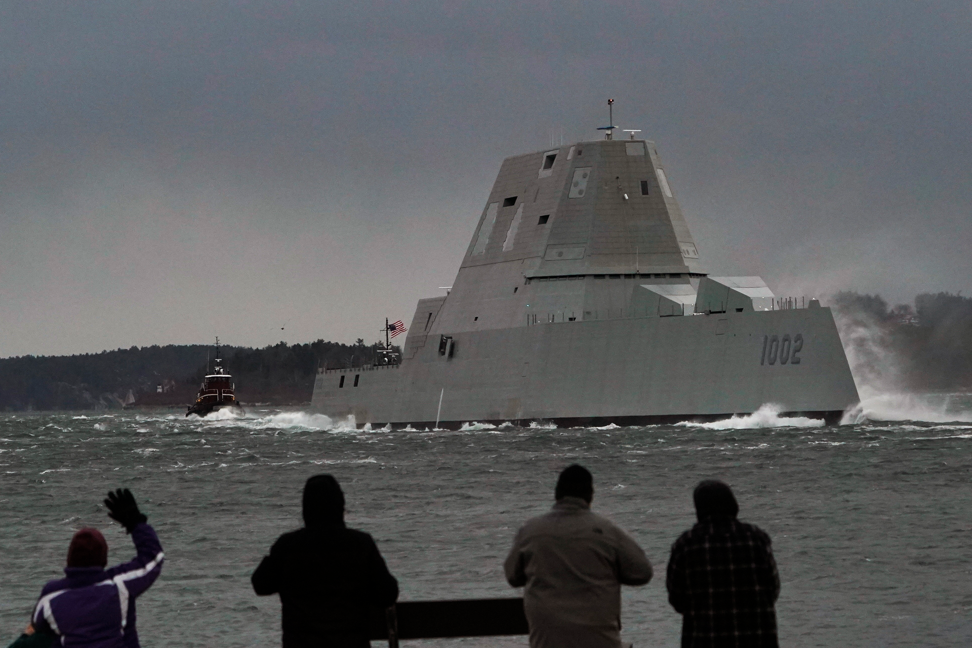 Spectators watch the USS Lyndon B. Johnson Zumwalt-class destroyer travel down the Kennebec River on its way to sea Jan. 12, 2022, in Phippsburg, Maine.