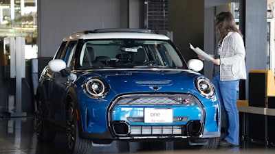 A potential buyer looks over a 2023 Cooper S sedan on the floor of a Mini dealership Friday, Feb. 17, 2023, in Highlands Ranch, Colo. Over the past year, the Fed has raised its key short-term rate eight times, causing many kinds of consumer and business loans, including auto loans, to become more expensive.