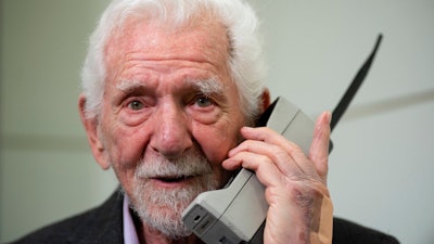 Marty Cooper, the inventor of first commercial mobile phone, poses for the press with a Motorola DynaTAC 8000x, during an interview with The Associated Press at the Mobile World Congress 2023 in Barcelona, Spain, Monday, Feb. 27, 2023. The four-day show kicks off Monday in a vast Barcelona conference center. It's the world's biggest and most influential meeting for the mobile tech industry.