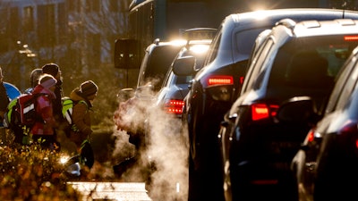 Cars give off exhaust fumes as children head to school in Frankfurt, Germany, on Monday, Feb. 27, 2023. Ever bigger cars pose a growing problem for the environment because they produce more greenhouse gas emissions and need larger batteries than their smaller cousins, according to the International Energy Agency.