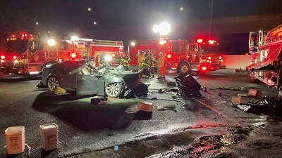 In this photo released by Contra Costa County Fire Protection District, firefighters work the scene of a fatal accident involving a Tesla and Contra Costa County fire truck early Saturday morning, Feb. 18, 2023, in Contra Costa, Calif.