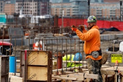A construction worker prepares a recently poured concrete foundation, March 17, 2023, Boston.