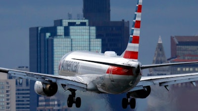An American Airlines plane lands at Logan International Airport, Thursday, Jan. 26, 2023, in Boston. Communities around the world emitted more carbon dioxide than any other year on record in 2022 as air travel rebounded from the pandemic and cities turned to coal to provide a cheap source of power.