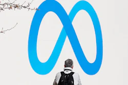 A person stands in front of a Meta sign outside of the company's headquarters in Menlo Park, Calif., Tuesday, March 7, 2023. Facebook’s parent Meta will slash another 10,000 jobs and will not fill 5,000 open positions as the social media pioneer cuts costs.