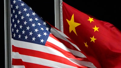 The American and Chinese flags wave at Genting Snow Park ahead of the 2022 Winter Olympics, Feb. 2, 2022, in Zhangjiakou, China. The Biden administration is close to finalizing new regulations that would tighten rules on certain overseas U.S. investment, a move aimed at limiting Beijing’s ability to acquire advanced technologies. That's according to a U.S. official familiar with deliberations who was not authorized to comment.