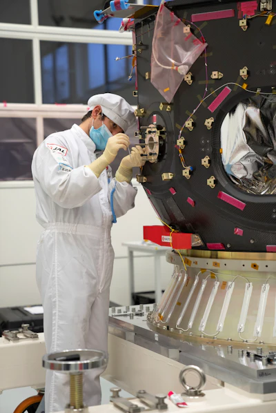 In this photo provided by ispace in April 2023, a technician works on the Hakuto spacecraft in Japan. On Tuesday, April 25, 2023, flight controllers plan to direct the craft to descend from orbit and land on the moon's surface.