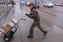 A United Parcel service driver wheels a delivery into the El Paso County, Colo., courthouse on Wednesday, Feb. 22, 2023, in Colorado Springs, Colo. On Friday, the U.S. government issues the March jobs report.