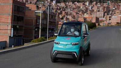 Dr. Carlos Ortuno drives a Bolivian-made, Quantum electric car to a house call, in La Paz, Bolivia, Wednesday, May 3, 2023.