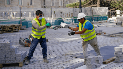 Two men work at a construction site during a heatwave in Madrid, Spain, Friday, Aug. 13, 2021.