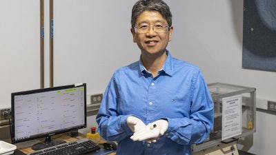 Jun Qu of ORNL shows stainless-steel disks before (silver) and after (black) coating with carbon nanotubes that provide superlubricity.