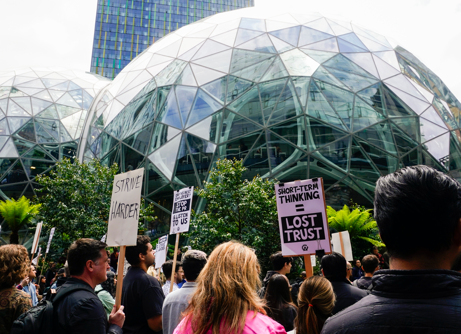 Amazon corporate workers hold picket signs in front of the Amazon Spheres, Seattle, May 31, 2023.