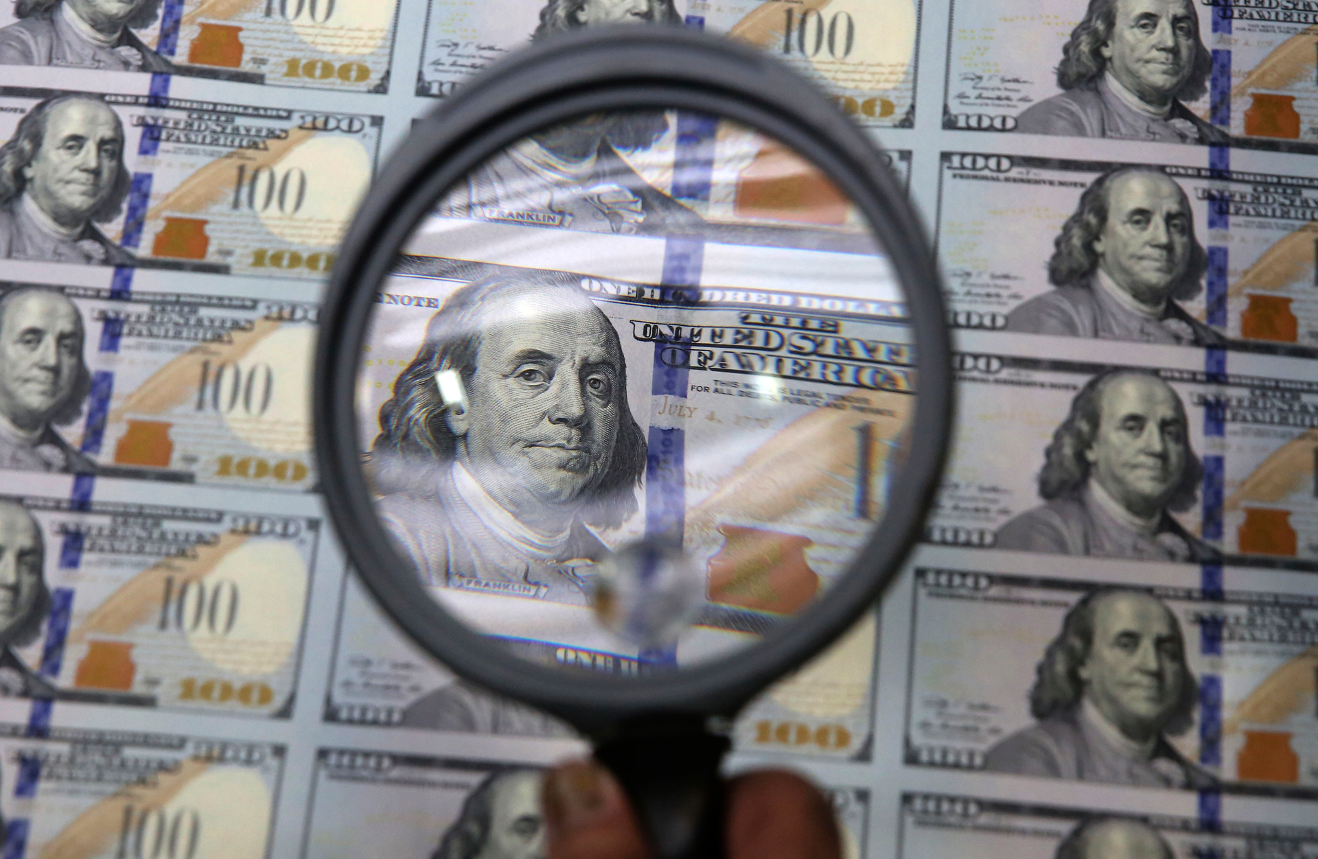 A sheet of uncut $100 bills is inspected during the printing process at the Bureau of Engraving and Printing Western Currency Facility in Fort Worth, Texas, on Sept. 24, 2013.