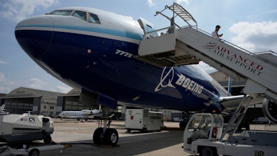 A man walks down the steps of the Boeing 777X airplane during the Paris Air Show in Le Bourget, north of Paris, France, Monday, June 19, 2023. Airlines are facing increasing pressure to cut their climate-changing emissions. That made sustainable aviation fuel a hot topic this week at the Paris Air Show, a major industry event. Sustainable fuel made from food waste or plant material is aviation's best hope for reducing emissions in the next couple of decades.