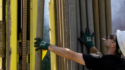 A Dandelion Energy employee inserts a drill extension while putting in a geothermal heat pump system at a home in White Plains, N.Y., Monday, May 8, 2023.