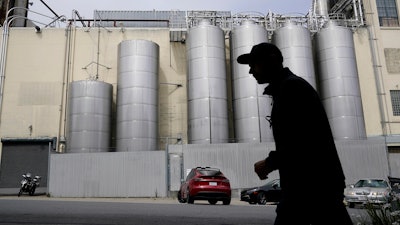 A person walks across the street from Anchor Brewing Co. in San Francisco, Wednesday, July 12, 2023. A spokesman for Anchor Brewing says the company is open to a purchase offer from its employees but warned that time is running out. The 127-year-old San Francisco-based trailblazer of craft beers stunned beer lovers earlier in July when it announced it would cease operations.