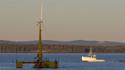 A lobster boat passes the country's first floating wind turbine off the coast of Castine, Maine, Sept. 20, 2013.