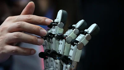 A visitor touches robotic fingers during the annual World Robot Conference at the Etrong International Exhibition and Convention Center on the outskirts of Beijing, Thursday, Aug. 17, 2023.