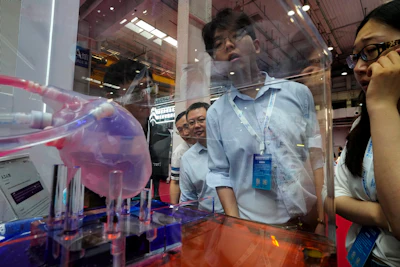 Visitors take a close look at an artificial heart during the annual World Robot Conference at the Etrong International Exhibition and Convention Center on the outskirts of Beijing, Thursday, Aug. 17, 2023.