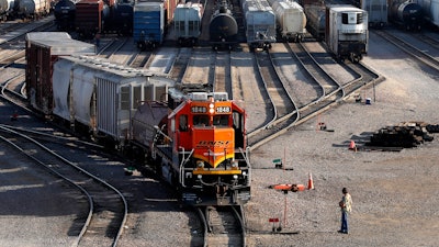 A BNSF rail terminal worker monitors the departure of a freight train, on June 15, 2021, in Galesburg, Ill.