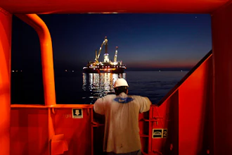 Wilson Ruiz, a crew member of the Joe Griffin, looks out at the oil slick at the site of the BP Deepwater Horizon offshore oil rig collapse in the Gulf of Mexico on May 6, 2010.