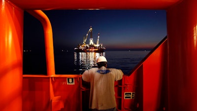 Wilson Ruiz, a crew member of the Joe Griffin, looks out at the oil slick at the site of the BP Deepwater Horizon offshore oil rig collapse in the Gulf of Mexico on May 6, 2010.