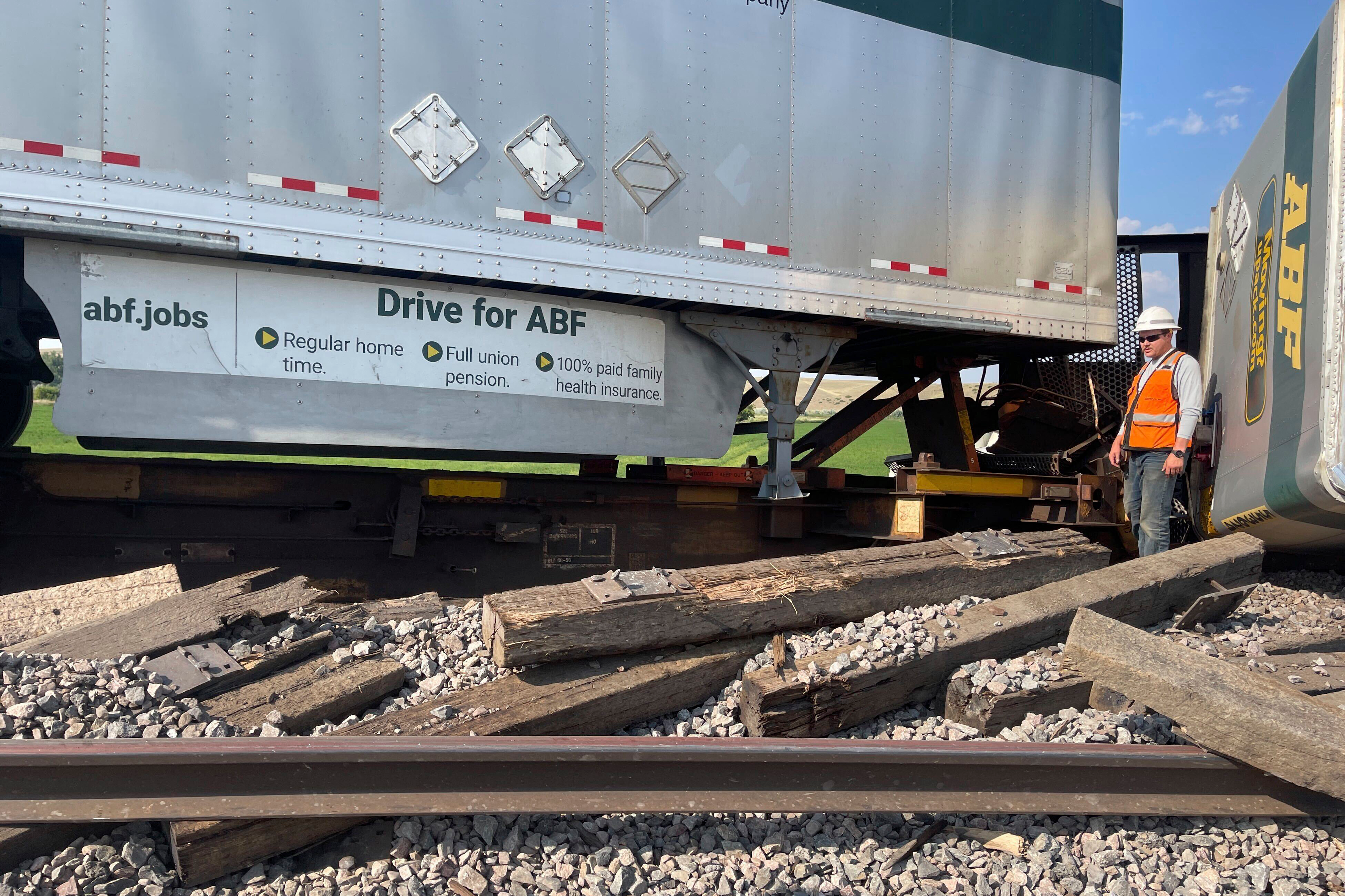 A worker stands among derailed freight cars near Havre, Montana, July 21, 2023.