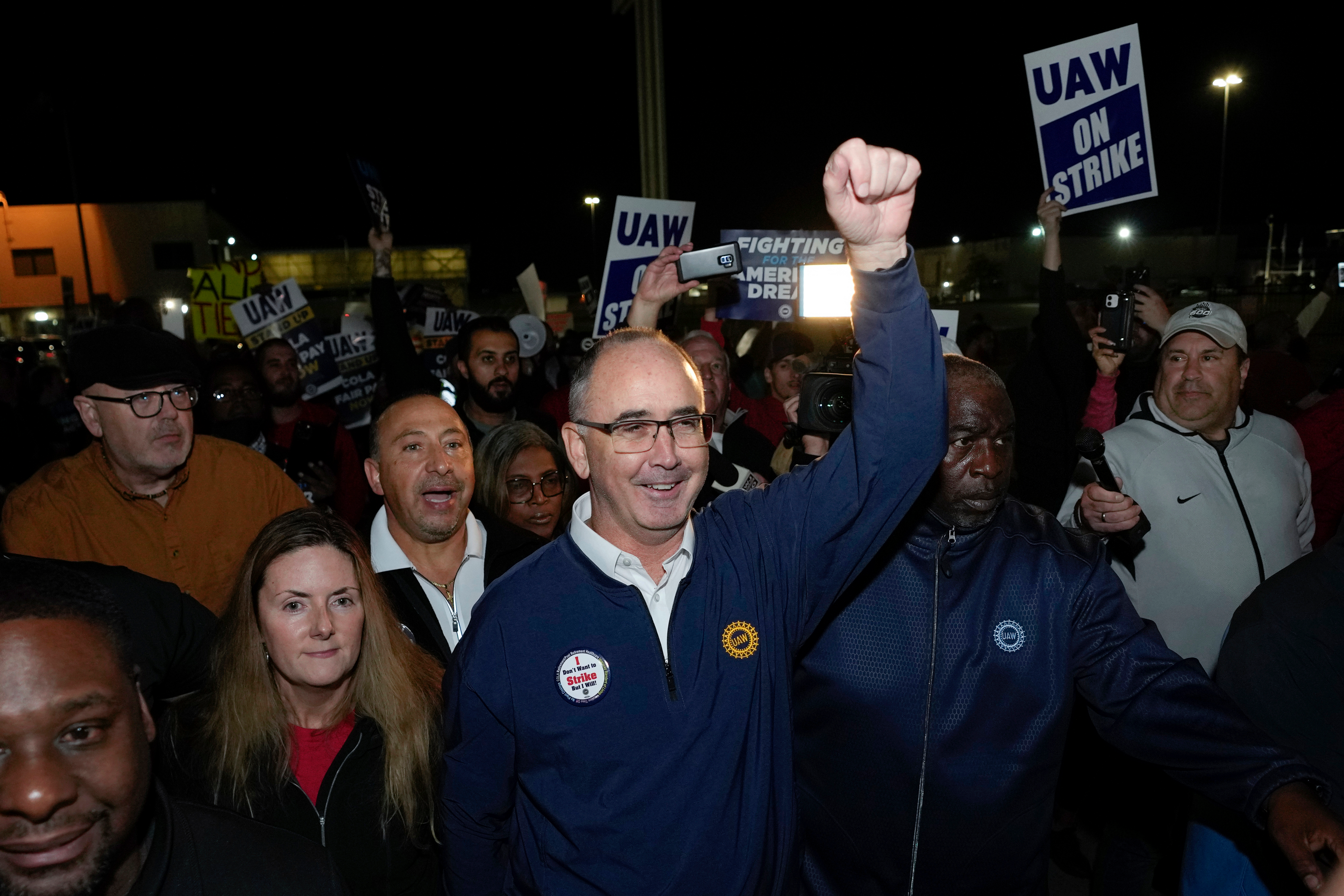 United Auto Workers President Shawn Fain walks with union members striking at Ford's Michigan Assembly Plant in Wayne, Mich., early Friday, Sept. 15, 2023.