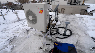 A condenser sits on the roof during the installation of a heat pump on Jan. 20, 2023, in Denver.