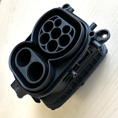 Real-world molded sample of a high-power charging inlet combo body previously tested in Moldflow software.