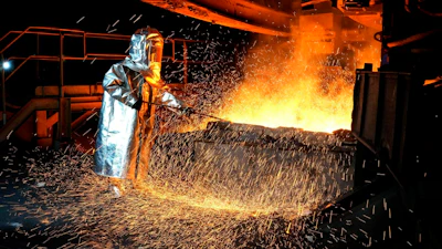 A worker in a protective suit pokes a metal rod to tap slag from a smelting furnace at PT Vale Indonesia's nickel processing plant in Sorowako, South Sulawesi, Indonesia, Tuesday, Sept. 12, 2023.