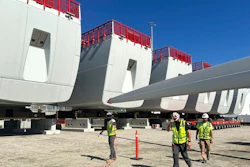 Workers walk by components of wind turbines being assembled at the State Pier in New London, Conn., on Wednesday, Oct. 4, 2023. The turbines will make up South Fork Wind Farm and eventually provide energy to New York.