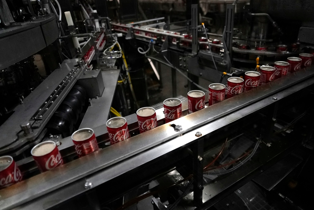 Coca-Cola cans move down a conveyer belt in the Swire Coca-Cola bottling plant Oct. 20, 2023, in Denver. Major corporations in water-guzzling industries such as apparel, food and beverage, and tech want to be better stewards of the freshwater resources they use. Coca-Cola said its water use in 2022 was about 10% more efficient compared to 2015.