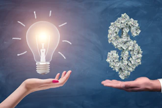 A Female And A Male Hands Holding A Large Bright Light Bulb And A Dollar Sign Made Of Many Money Bills 1176792626 2123x1416