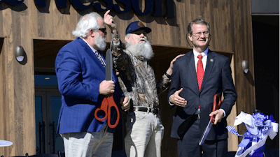 Blount County Mayor Ed Mitchell, from left, Si Robertson of 'Duck Dynasty' and U.S. Representative Tim Burchett, R-Tenn, hold their ceremonial scissors Saturday, Oct. 7, 2023, after helping cut the ribbon to officially open the new Smith & Wesson facility in Maryville, Tenn.