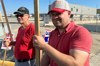 Striking United Auto Workers member Chris Jedrzejek, right, and his father picket outside Ford Motor Co.'s Michigan Assembly Plant Monday, Oct. 2, 2023, in Wayne, Mich.