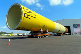 A huge foundation for an Orsted offshore wind turbine, called a monopile, sits atop wheeled movers in Paulsboro, N.J., July 6, 2023.