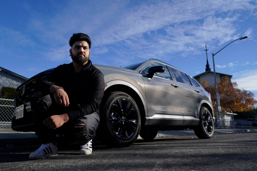Shalinder Singh poses for photos in front of a 2024 Honda CR-V Hybrid in Sunnyvale, Calif., Monday, Dec. 11, 2023.