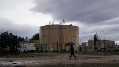 Ileana Miranda walks in front of the new San Jerardo cooperative water tank in Salinas, Calif., Dec. 20, 2023.