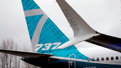 In this Feb. 5, 2018, file photo, a dual-tipped wing tip, known as a 'winglet,' stands in view of the tail of a Boeing 737 MAX 7, the newest version of Boeing's fastest-selling airplane, while displayed during a debut for employees and media of the new jet in Renton, Wash.