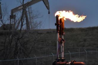 A flare burns at a well pad Aug. 26, 2021, near Watford City, N.D.