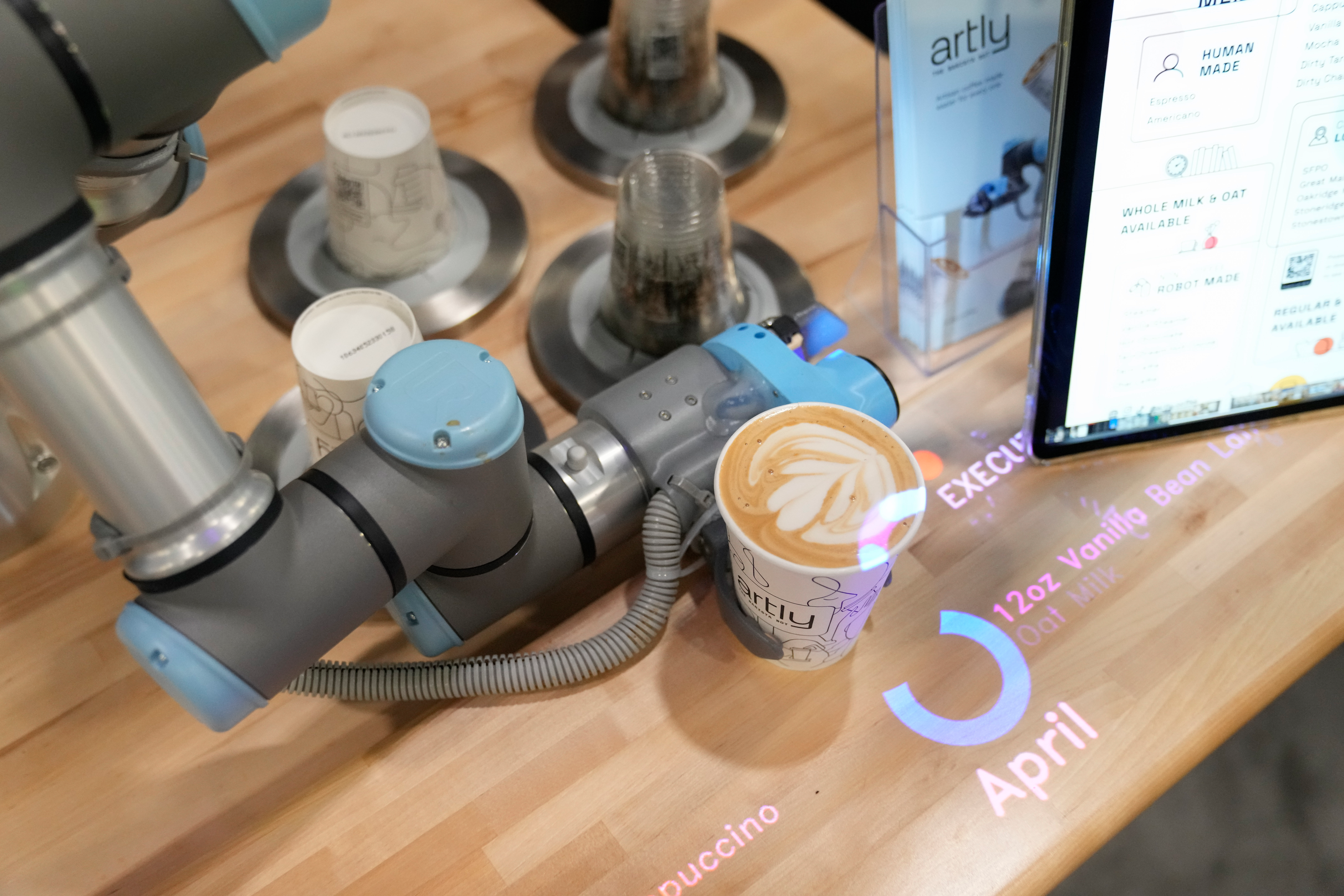 The Artly barista robot serves a drink during the CES tech show, Las Vegas, Jan. 10, 2024.